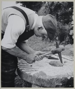 Mr Arthur Robinson, former miller of Rievaulx, dressing a millstone. Probably associated with the series of photographs used to illustrate  