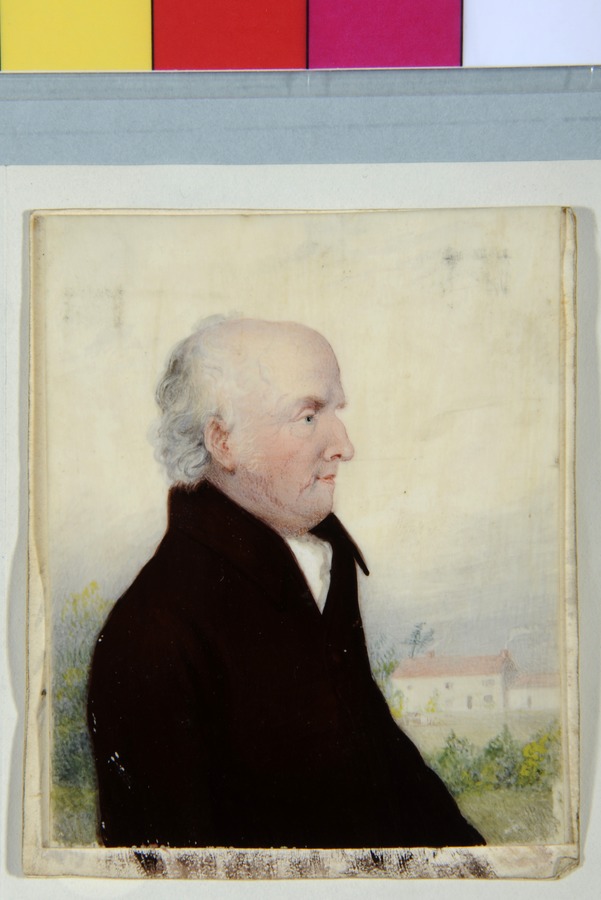 An elderly gentleman, with farmhouse in background